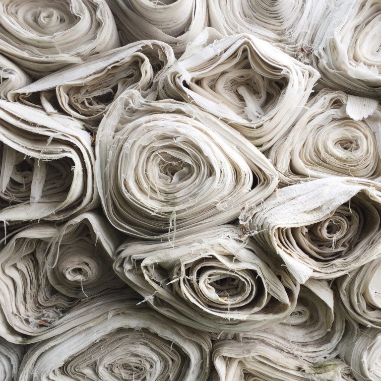 A pile of newspapers that are rolled up.